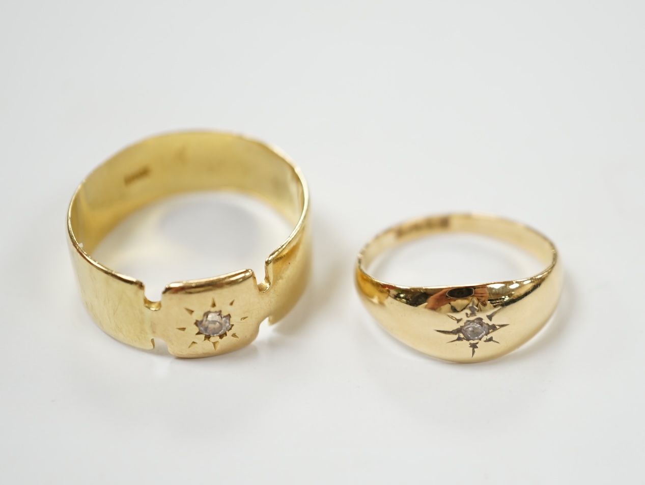 Two 18ct and single stone diamond chip set bands, largest size S, gross weight 7.7 grams. Condition - fair